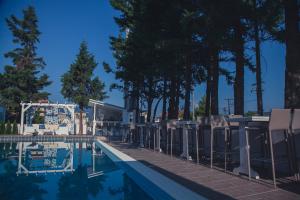 einen Pool mit Stühlen und Bäumen neben einem Haus in der Unterkunft Hotel Philippos Livadeia in Livadia