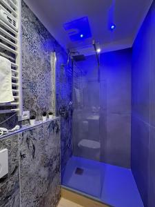 a bathroom with a shower with a blue ceiling at La Suite Deluxe Rooms & Apartments in Bologna