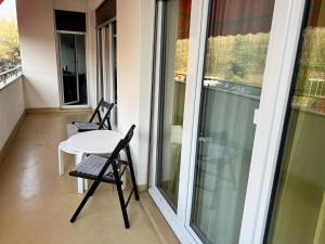 balkon ze stołem i 2 krzesłami w obiekcie Agréable appartement près du lac w mieście Versoix