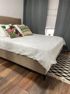 a bed with white sheets and pillows in a bedroom at A new Jaffa gallery apartment a minute from the beach and entertainment centers in Tel Aviv