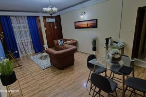 - un salon avec une table en verre et un canapé dans l'établissement Grace Apart Bastos Yaoundé, à Yaoundé
