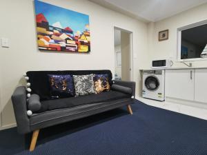 een woonkamer met een bank en een magnetron bij Rose Room in Auckland +19 foto's