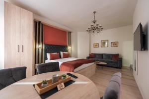 a bedroom with a bed and a living room at Apartments Artee Free Garage Parking in Sarajevo