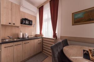 a small kitchen with a table and a sink at Apartments Artee Free Garage Parking in Sarajevo