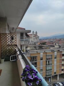 - un balcon avec des fleurs violettes dans un bâtiment dans l'établissement Al Tochetìn, à Schio