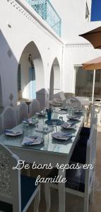 a table with plates and napkins on top of it at Villa La Palmeraie d'Arkou, grande piscine in Arkou