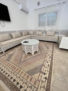 ein Wohnzimmer mit einem Sofa und einem Tisch in der Unterkunft Villa La Palmeraie d'Arkou, grande piscine in Arkou