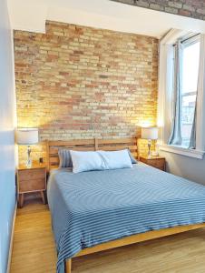 a bedroom with a brick wall and a bed at Tanner Building in Bay City
