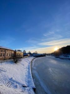 a road covered in snow with the sun in the background at Rune Bergin piilopaikka in Porvoo