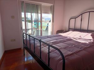 a bedroom with a bed and a large window at Casa Azul em Chaves in Chaves