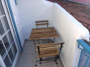 twee banken en een tafel naast een gebouw bij Casa Azul em Chaves in Chaves