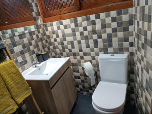 a bathroom with a white toilet and a sink at Casa Azul em Chaves in Chaves