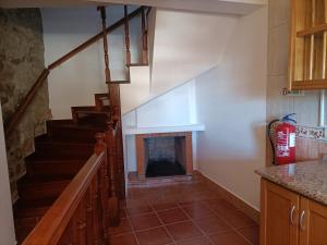 a staircase in a kitchen with a fire place at Charming Casa Azul - Stay in Historic Chaves in Chaves