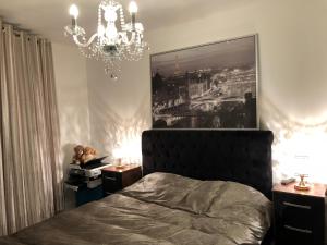 a bedroom with a bed and a chandelier at Luxury Apartment North Greenwich London in London