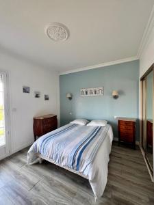 een slaapkamer met een bed en een blauwe muur bij Villa Pougeol - Charmante Villa Calme & Paisible - Avec Piscine & Terrain de Pétanque in Chanac-les-Mines