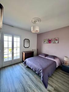 een slaapkamer met een groot bed en een raam bij Villa Pougeol - Charmante Villa Calme & Paisible - Avec Piscine & Terrain de Pétanque in Chanac-les-Mines