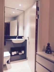 a bathroom with a sink and a toilet and a mirror at Luxury Apartment North Greenwich London in London