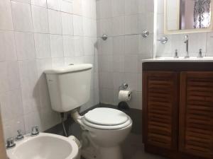 a white bathroom with a toilet and a sink at Departamento Centrico travel & business in San Salvador de Jujuy +9 photos