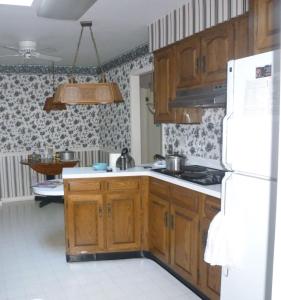 - une cuisine avec des placards en bois et un réfrigérateur blanc dans l'établissement Queen Room, à Huntington