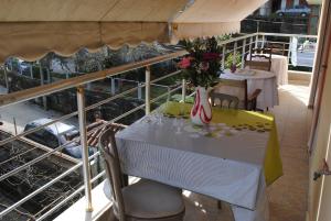 einen Tisch mit einer Blumenvase auf dem Balkon in der Unterkunft George's Apartment in Gjirokastër