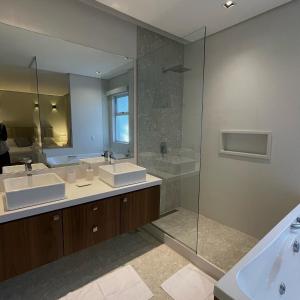 un bagno con due lavandini e un grande specchio di Casa 09 Monte Boa Vista - Refúgio com Piscina Privativa, Sauna e Vista das Montanhas a Teresópolis