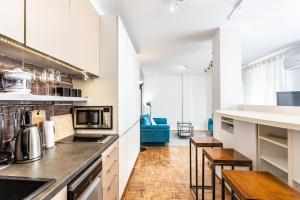 une cuisine avec des placards blancs et un comptoir dans l'établissement Lovely Studio with a big terrace, à Belgrade