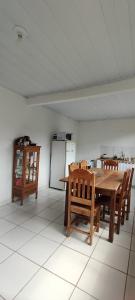 cocina con mesa, sillas y nevera en Casa Vista para Serra, en Tiradentes