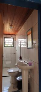a bathroom with a toilet and a sink at Casa Vista para Serra in Tiradentes