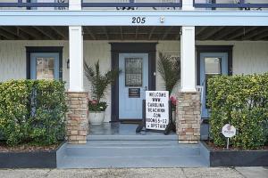 ein Haus mit einem Schild an der Eingangstür in der Unterkunft Carolina Beach Inn in Carolina Beach