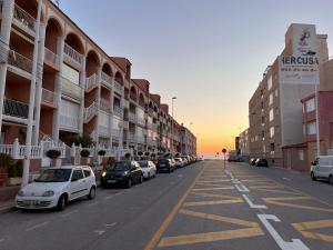 una strada con auto parcheggiate sul lato di un edificio di APJ Emperadores Apartment with swimming pool, 100 m from beach La Mata a La Mata