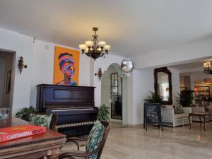 een woonkamer met een piano in het midden van een kamer bij Hotel Kartaxa in Cartagena