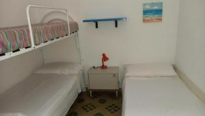 two bunk beds in a small room with a table at Baia Santa Maria in Cittadella del Capo