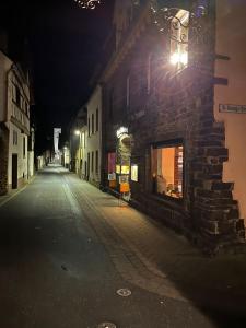 eine leere Straße in der Nacht mit einem Gebäude in der Unterkunft Mike‘s Mosel Lodge in Treis-Karden