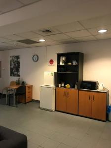 a room with a refrigerator and a table and a clock at Aleja "Solidarności" in Warsaw