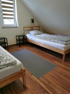 a bedroom with two beds and a rug at Przy Przystani in Stegna
