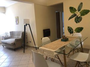 a living room with a glass table and chairs at Departamento Centrico travel & business in San Salvador de Jujuy