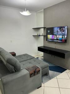 sala de estar con sofá y TV de pantalla plana en APARTAMENTO AMPLO COMPLETO (SUITE/QUARTO), en Americana