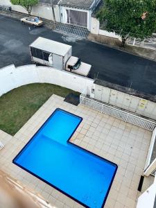 una vista aérea de una piscina azul en un patio en APARTAMENTO AMPLO COMPLETO (SUITE/QUARTO), en Americana
