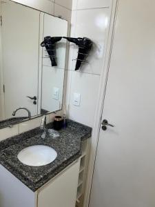 y baño con lavabo y espejo. en APARTAMENTO AMPLO COMPLETO (SUITE/QUARTO), en Americana