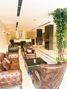 a lobby with leather chairs and a table at Arad Otel in Urfa