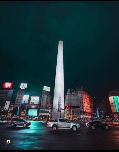 Una ciudad de noche con un obelisco en el fondo en Lindo Apartamento a una cuadra del obelisco en Buenos Aires