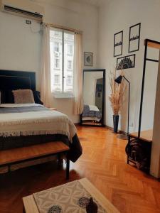 1 dormitorio con 1 cama y suelo de madera en Lindo Apartamento a una cuadra del obelisco en Buenos Aires