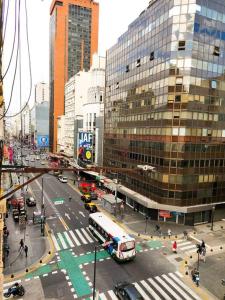 una concurrida calle de la ciudad con un autobús en un concurrido en Lindo Apartamento a una cuadra del obelisco en Buenos Aires