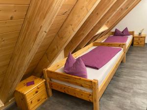 two beds in a room with wooden ceilings at Ferienbauernhof-Holops in Sankt Georgen im Schwarzwald