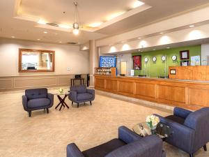 uma sala de espera com cadeiras azuis e uma área de espera em New Gardena Hotel em Gardena