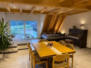 ein Wohnzimmer mit einem Tisch und einem Klavier in der Unterkunft Ferienbauernhof-Holops in Sankt Georgen im Schwarzwald