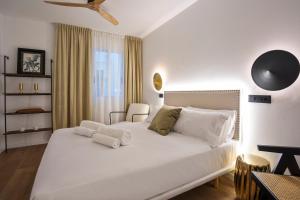 Un dormitorio con una gran cama blanca y una mesa en Hotel Casa Trafalgar Barcelona, en Barcelona