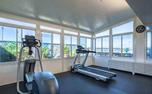 a gym with two exercise bikes in a room with windows at New Gardena Hotel in Gardena