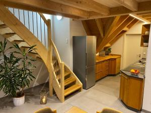 a kitchen with a staircase and a stainless steel refrigerator at Ferienbauernhof-Holops in Sankt Georgen im Schwarzwald +23 photos
