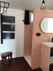 a bathroom with a sink and a mirror and a stool at La Maison 1440 in L'Isle-sur-la-Sorgue